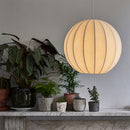 Globe Shaped Fibre Silk Globe Lampshade on a pendant light  casting a soft glow over a shelf with plants.