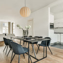 Modern black dining table and chairs in a white room with wooden flooring with a Fibre Silk Globe Lampshade hung over the table.
