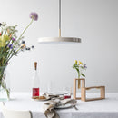 White Umage Asteria Pendant Light above a table with a white table cloth and white walls