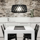 Large Pilke Black Birch Wooden Pendant Light above a white Dining table with Black Chairs