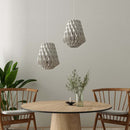
 A Pair of Pilke White Wooden Pendant Lights above a dining table and chairs