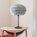 A Wooden Table with a black lamp with a Grey Feather Lampshade by Umage.